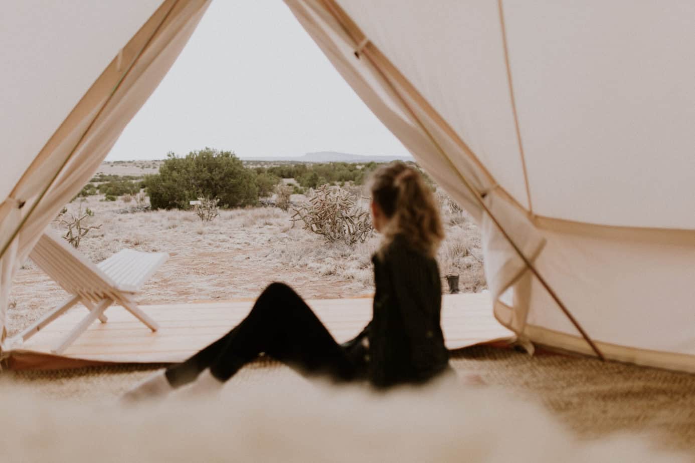 Girl Looking at Desert View in Canvas Safari Tent at Glamping Retreat in New Mexico