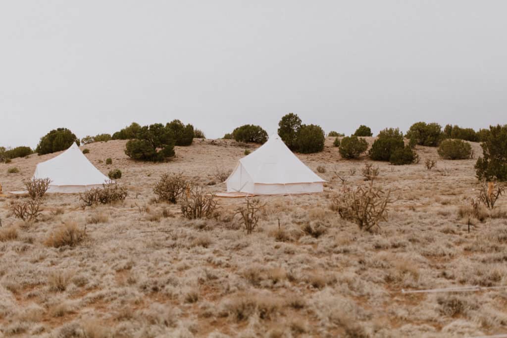 White Canvas Safari Tents at Luxury Glamping Retreat in New Mexico Surrounded by Desert Landscape